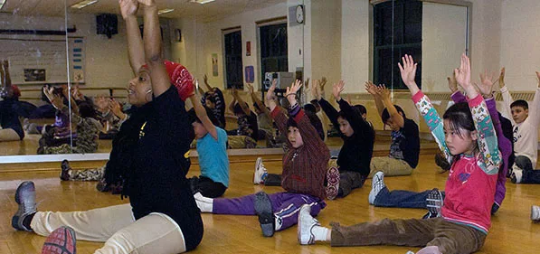 Teacher leads an exercise class for young students