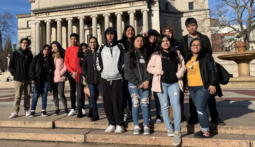 A group of young adults at Columbia University in front of the library