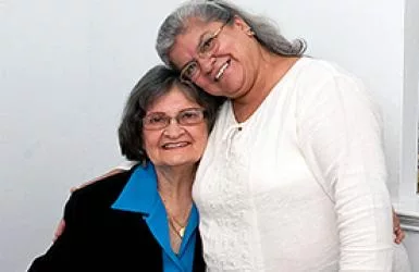 Two women standing close and smiling